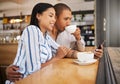 Couple using social media on a phone and drinking tea in a coffee shop together. Happy man and woman with 5g mobile Royalty Free Stock Photo
