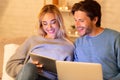 Couple Using Tablet And Laptop Sitting On Couch Indoor Royalty Free Stock Photo