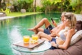 Couple using their mobile phones by the pool Royalty Free Stock Photo