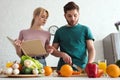 couple of vegans preparing food with recipe book