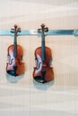 Couple of vintage violin hanging on metal hook Royalty Free Stock Photo