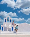 Couple visit Santorini Greece, men and women visit the whitewashed Greek village of Oia