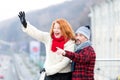 Couple wag to air. Red hair woman wag from the bridge. Happy lady with guy welcomes to friends. Royalty Free Stock Photo