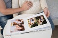 Couple waiting for baby flips through photo book from family photo shoot