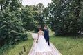 A couple walk along a wooden path among the trees in the park