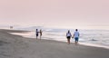 Couple walk on the beach holding hands at sunset near corolla NC