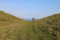 A couple walk in a dip in the hills at Seatown in Dorset, situated on the coastal path on the Jurassic coast between Charmouth and Royalty Free Stock Photo