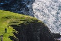 A couple walk near stunning dusk cliff, Scotland, UK