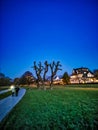 Couple Walk on a pathway in moonlight on a winter evening with a big cutted tree on the green grass in nature at the riverside