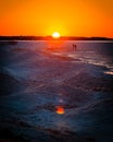 Couple walking across the ice dunes of a Frozen Lake Michigan in winter at sunset Royalty Free Stock Photo