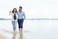 couple walking along tideline Royalty Free Stock Photo