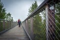 Couple walking along treetop walkway in Bachledova dolina in Slovakia