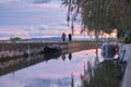 Couple walking in the autumn sunset walking through a canal with boats Royalty Free Stock Photo