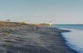 A couple walking barefoot on the black sand beach