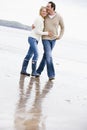 Couple walking on beach arm in arm smiling Royalty Free Stock Photo