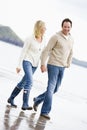 Couple walking on beach holding hands smiling Royalty Free Stock Photo