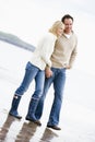 Couple walking on beach holding hands smiling Royalty Free Stock Photo