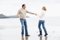 Couple walking on beach holding hands smiling Royalty Free Stock Photo