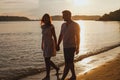 couple walking on the beach, honeymoon holidays, silhouettes of man and woman holding hands Royalty Free Stock Photo