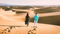 couple walking at the beach of Maspalomas Gran Canaria Spain, men and woman at the sand dunes desert