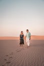 Couple walking at the beach of Maspalomas Gran Canaria Spain, men and woman at the sand dunes desert of Maspalomas