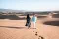 Couple walking at the beach of Maspalomas Gran Canaria Spain, men and woman at the sand dunes desert of Maspalomas