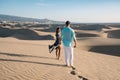 Couple walking at the beach of Maspalomas Gran Canaria Spain, men and woman at the sand dunes desert of Maspalomas