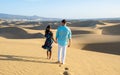 couple walking at the beach of Maspalomas Gran Canaria Spain, men and woman at the sand dunes desert Royalty Free Stock Photo