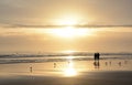 Couple walking on beach at sunrise. Royalty Free Stock Photo