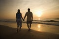 Couple walking on beach at sunset. Royalty Free Stock Photo