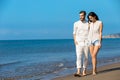 Couple walking on beach. Young happy interracial couple walking on beach smiling holding around each other. Royalty Free Stock Photo