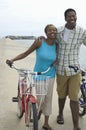 Couple Walking With Bicycles At Beach Royalty Free Stock Photo