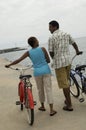 Couple Walking With Bicycles On Beach Royalty Free Stock Photo