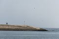 Couple walking breakwater built concrete blocks pier ocean salalah oman Royalty Free Stock Photo