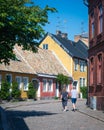 Couple walking on cobblestoned street by colorful houses in medieval Lund Sweden