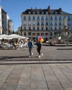 Couple walking in denim jacket and holding colored balloons in the city square in on a sunny day