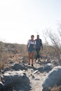 Couple walking through the desert on a rocky path Royalty Free Stock Photo