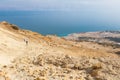 Couple walking desert trail down to Dead sea. Royalty Free Stock Photo