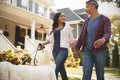 Couple Walking Dog Along Suburban Street Royalty Free Stock Photo