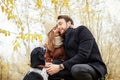 Couple walking with dog in the Park and hugging. Autumn walk in Royalty Free Stock Photo