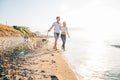 Couple walking with dogs on beach