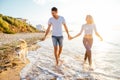 Couple walking with dogs on beach Royalty Free Stock Photo