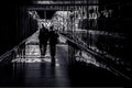 Couple walking down contrasted corridor