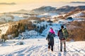 Couple walking down the snowy mountain in sunset time Royalty Free Stock Photo