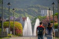 A couple walking down a stone pathway towards a fountain.