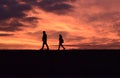 Couple walking down a very orange sunset Royalty Free Stock Photo