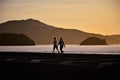 Couple walking on the edge of MassaguaÃ§u beach at dawn Royalty Free Stock Photo
