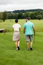 Couple walking on a golf course Royalty Free Stock Photo