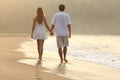 Couple walking and holding hands on the sand of a beach Royalty Free Stock Photo