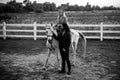 Couple walking with horse on countryside. Handsome bearded man driving horse for a bridle and looking at his girlfriend Royalty Free Stock Photo